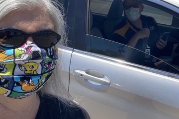 A lady Wear a mask with picture designs and a cooling glass
