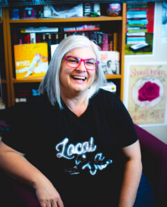 Dani Cutler in her studio in a chair laughing 